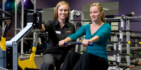 Murdoch chiropractic student helping patient on rowing machine