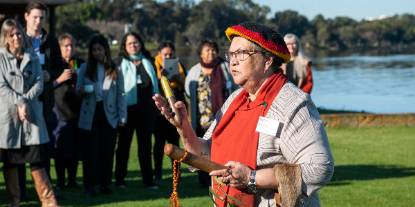 aboriginal elder with message sticks in her hand