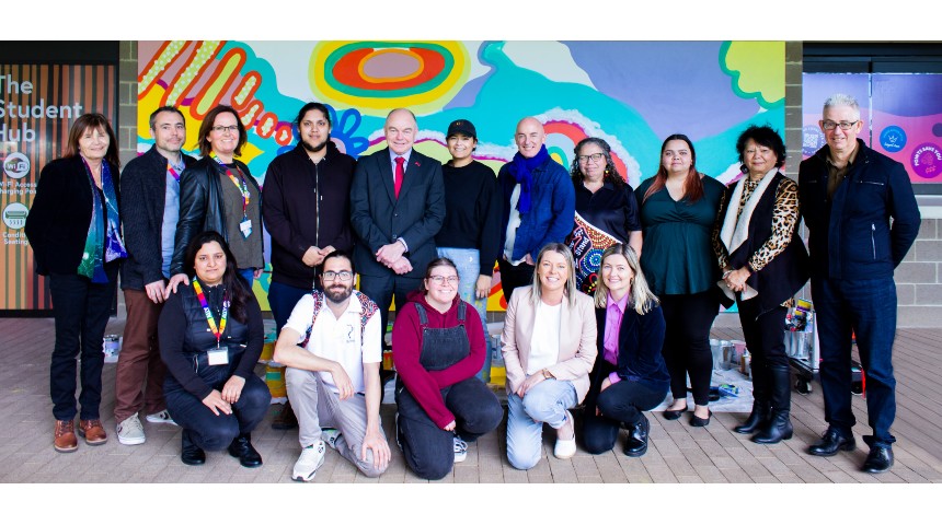Murdoch University stakeholders who were involved in the project lined up for a photo in front of the mural with Jarni McGuire.