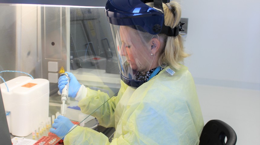 A researcher in PPE preparing COVID samples