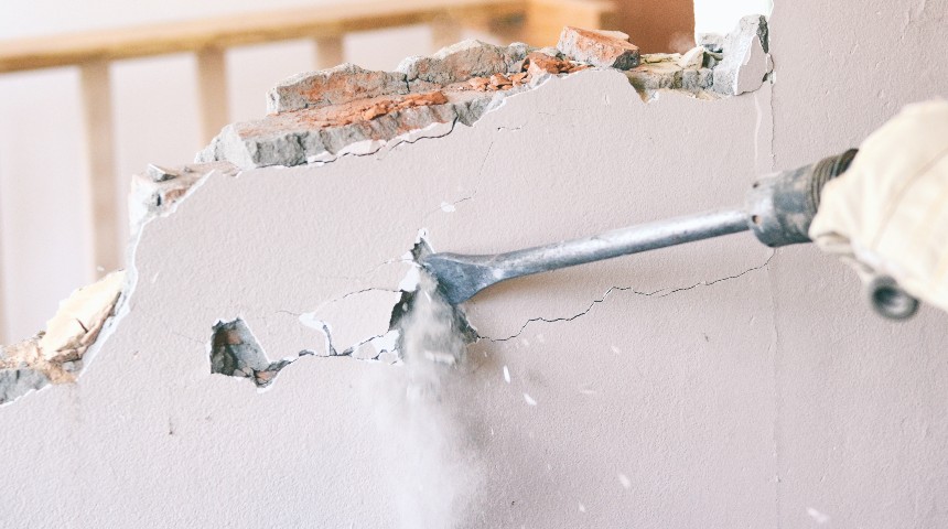Person renovating house by knocking down wall