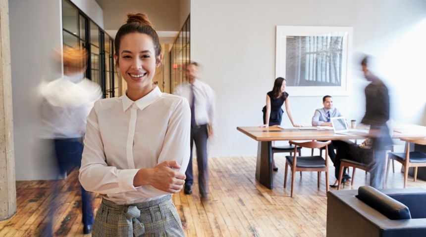 Professional woman smiling in a busy office