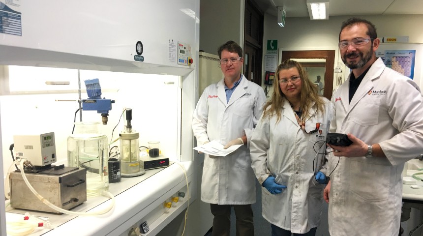 three people in lab coats standing in a lab
