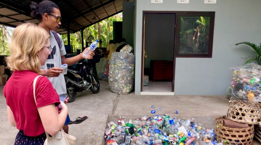 people looking at empty plastic bottles for recycling