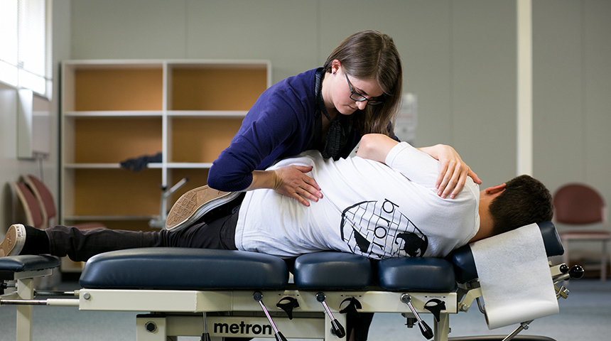 Female chiropractor performing adjustment on male patient