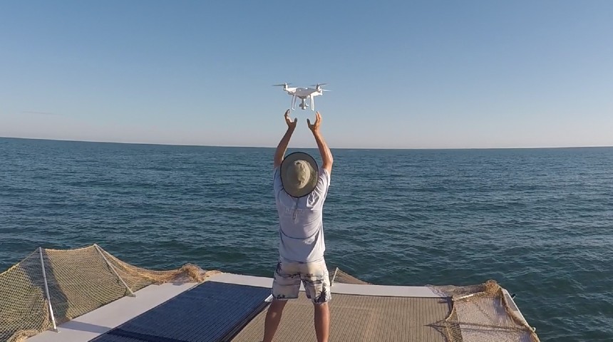 man launching drone off a boat