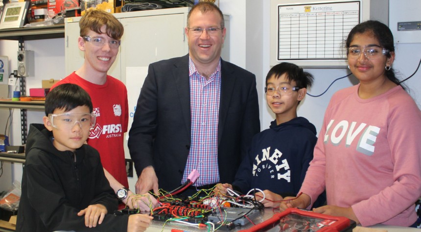 Students with Ben Morton building a robot at a table