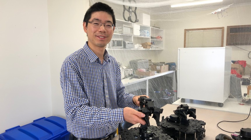 Dr Wai Hang in a lab with robots