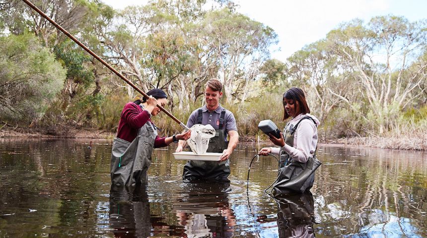Murdoch students standing in lake testing water