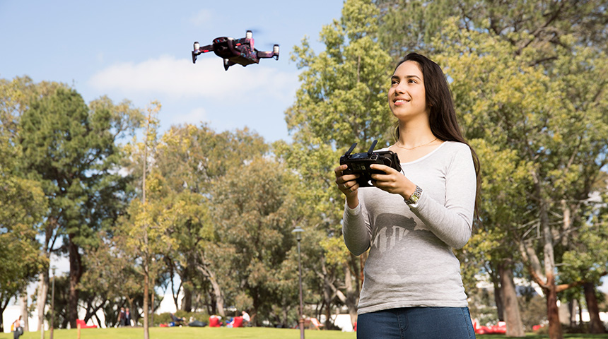 Female student flies drone outside.
