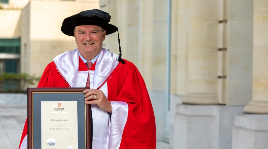Dr Mathias Cormann holding his Honourary Doctorate
