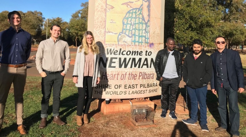 Murdoch students, academics and graduates stand in front of Newman town entrance
