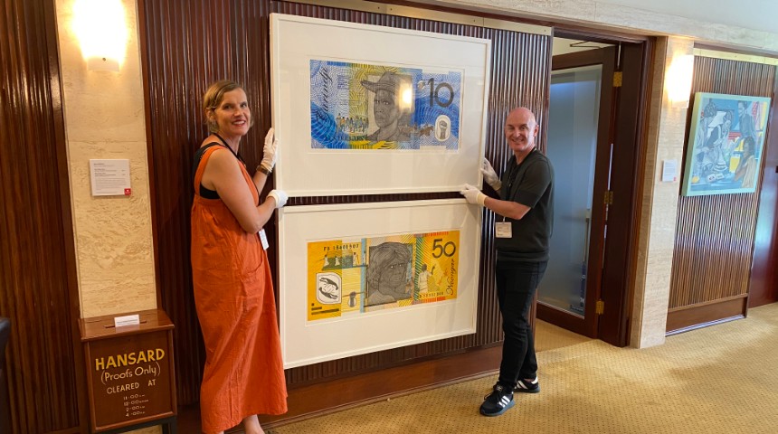 Murdoch curators Mark Stewart & Jane Chambers installing artworks resembling money by Ryan Presley 