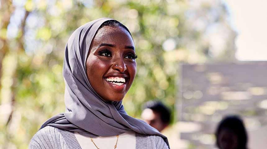 Female student wearing hijab smiling.