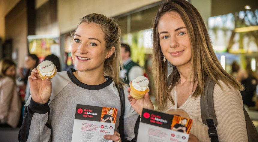 two girls holding student portal cupcakes
