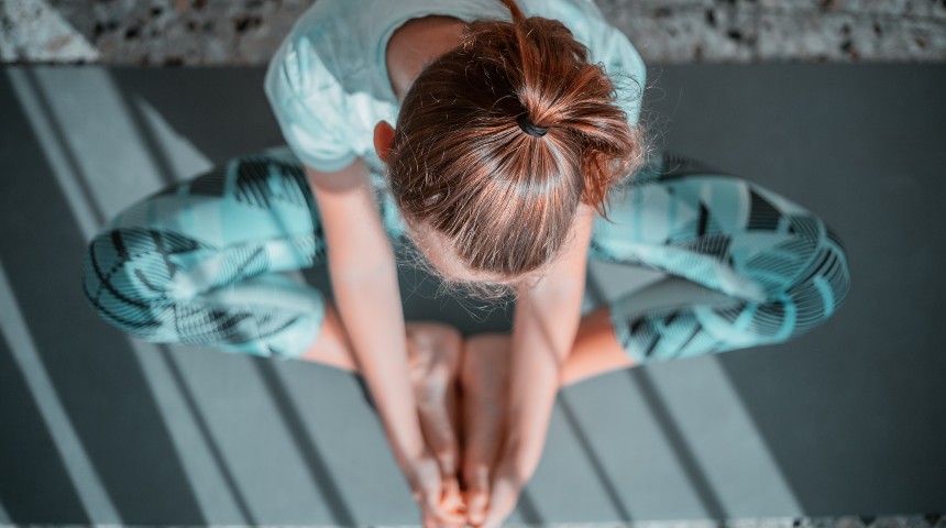 Child doing a yoga pose, shown from a high camera angle looking down.