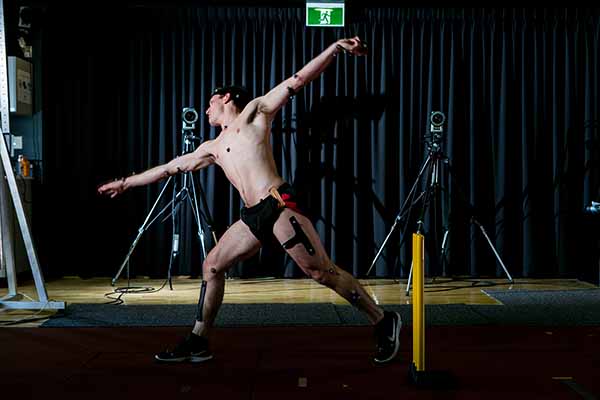 Cricket player bowling with electrodes attached for gait analysis 