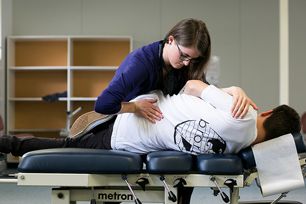 Female chiropractor performing adjustment on male patient