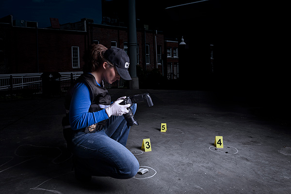 Forensic student examining crime scene with camera