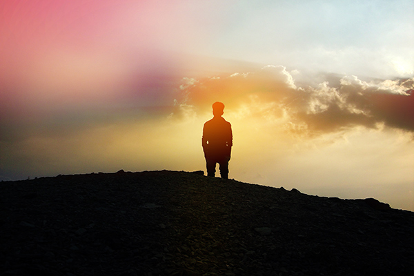 Silhouette of person standing on a hill